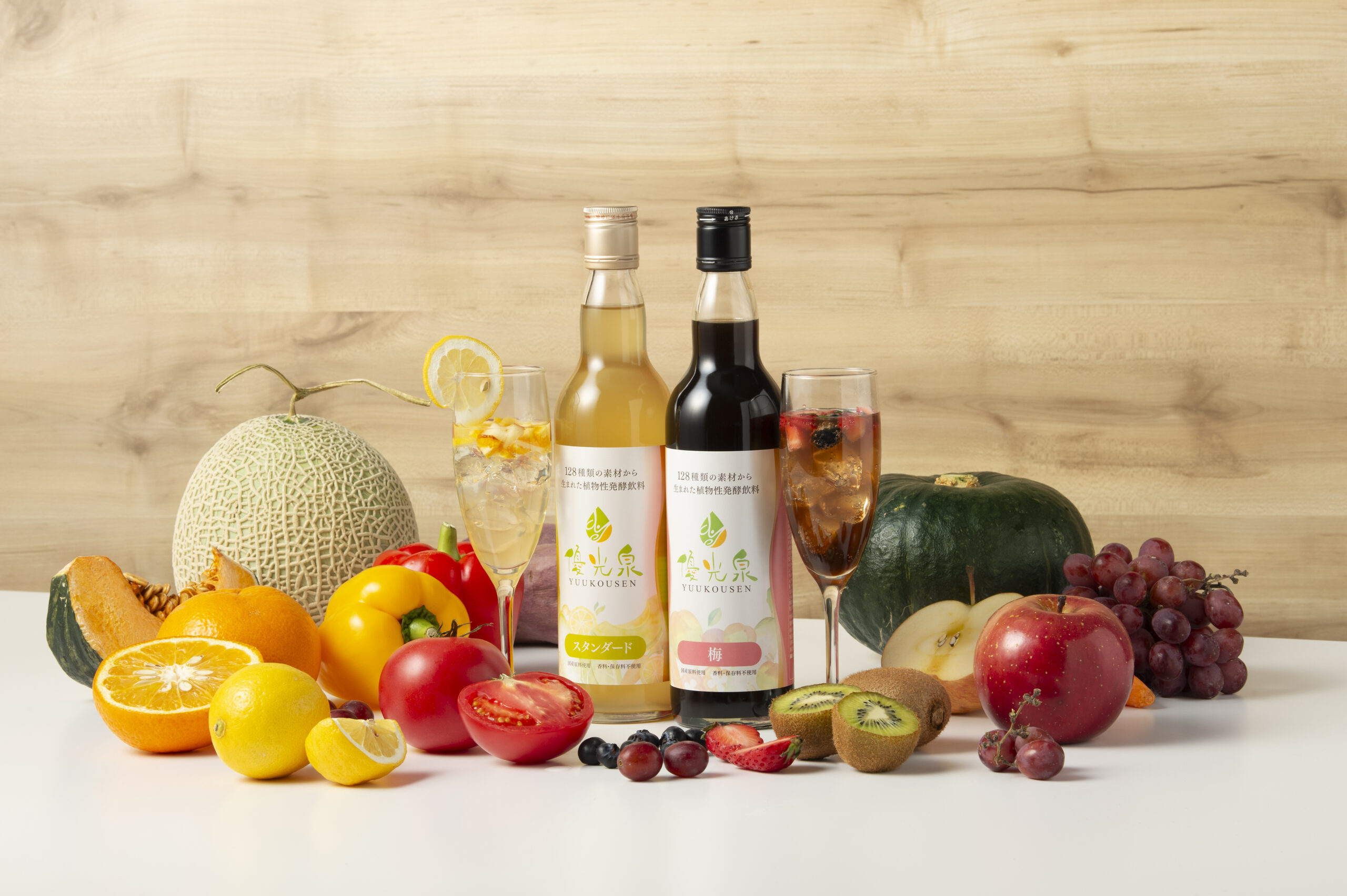 優光泉のボトルに入った酵素ドリンクと、周りに並べられた新鮮な野菜や果物。健康的でクリーンなライフスタイルをイメージさせる写真。